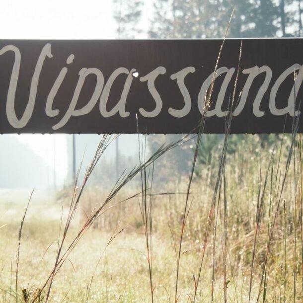 Vipassana retreat sign with a bullet hole above the a.