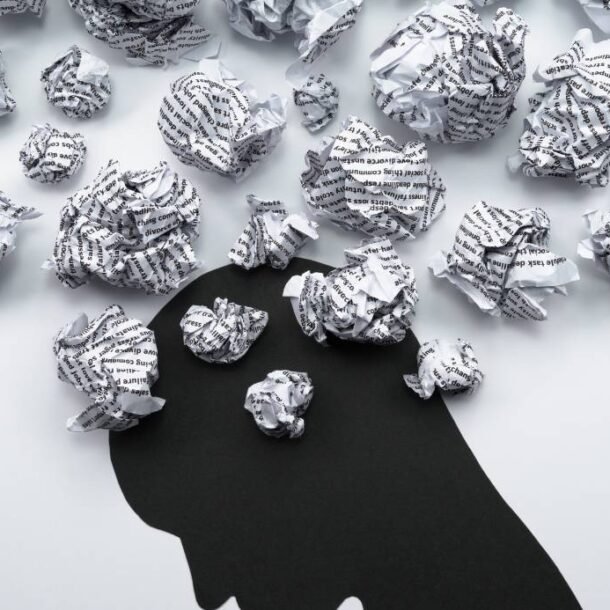 Negative self-talk image of a shadowed figured surrounded by thoughts.
